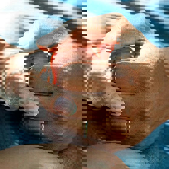 Två händer som håller i varandra. En yngre tar hand om en äldre