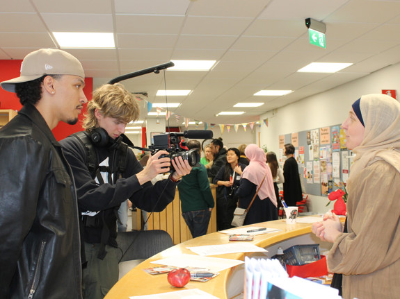 Projektledaren för kunskapsseminariet om brottsförebyggande arbete blir filmad av deltagare på skolan