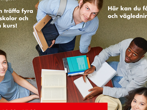 Bild tagen uppifrån. Tre personer sitter på varsin sida av ett bord med block och pennor på. En person står upp vid änden av bordet. Alla tittar uppåt mot kameran.