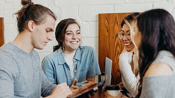 Fyra deltagare står och hänger på ett högt bord. De pratar och skrattar tillsammans