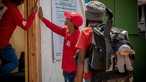 En flicka på flykt i Panama får vatten av hjälparbetare