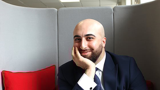 Nöjd kille i fåtölj som precis fått sin gymnasiebehörighet på folkhögskola. Närbild