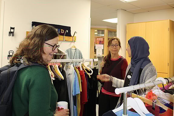 Tre kvinnor, tittar runt i Vintagehörnan med secondhandkläder på Röda Korsets folkhögskola