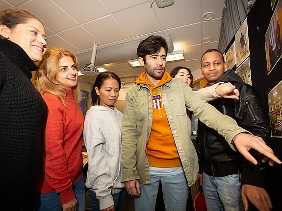 En grupp deltagare på den allmänna kursen Vi i samhället visar en fotoutställning de gjort tillsammans