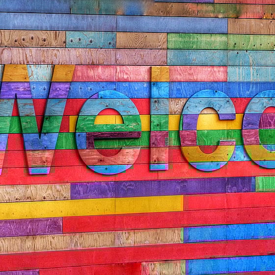 Ordet Welcome står skrivet på en färgglad bakgrund