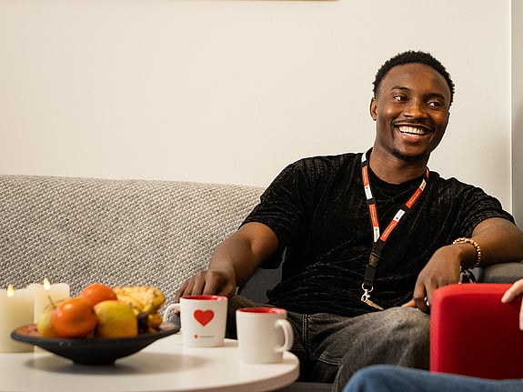 Ung man sitter och tittar ner i en bok. Ser glad ut.