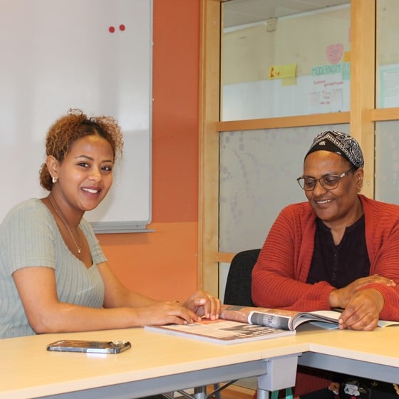 Två kvinnliga kursdeltagare studerar tillsammans